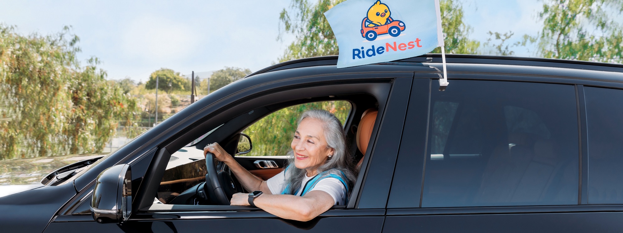 A screened Nest Driver at the wheel with the RideNest flag
